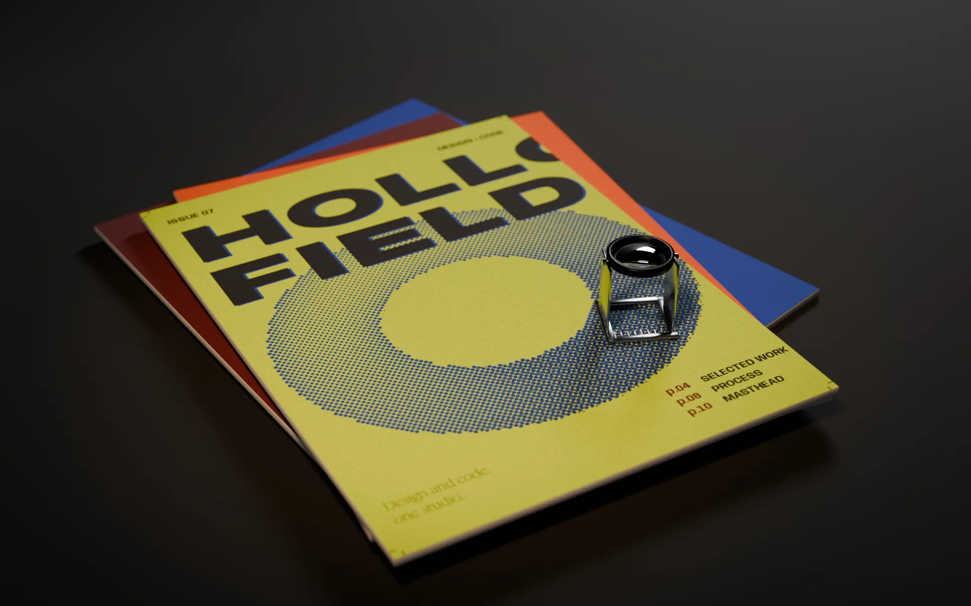 The same copies of Issue 07 at night, in a warm pool of desk light on black stock.