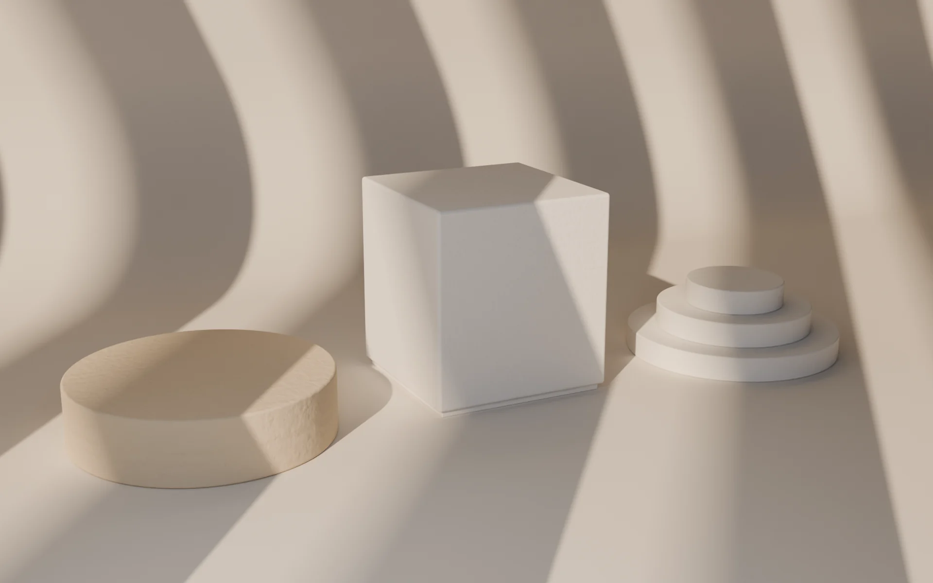 Three plaster objects under striped light from studio blinds: a low round table in warm plaster, a tall cube stool and a three-step stand.
