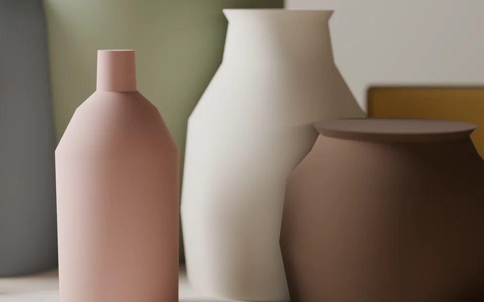 A close study of a dusty rose bottle between a sage vase and a white jug, soft focus.