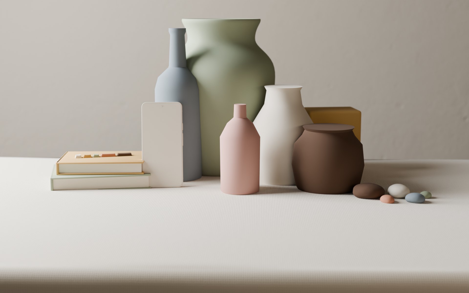 A tight still life on a linen-covered table in soft side light: a large sage vase, a tall slate bottle, a white jug, a dusty-rose flask, an ochre tin and an umber pot, with a phone leaning against two books topped with five keycaps, and a few river stones, all in matte chalk paint against a plaster wall.