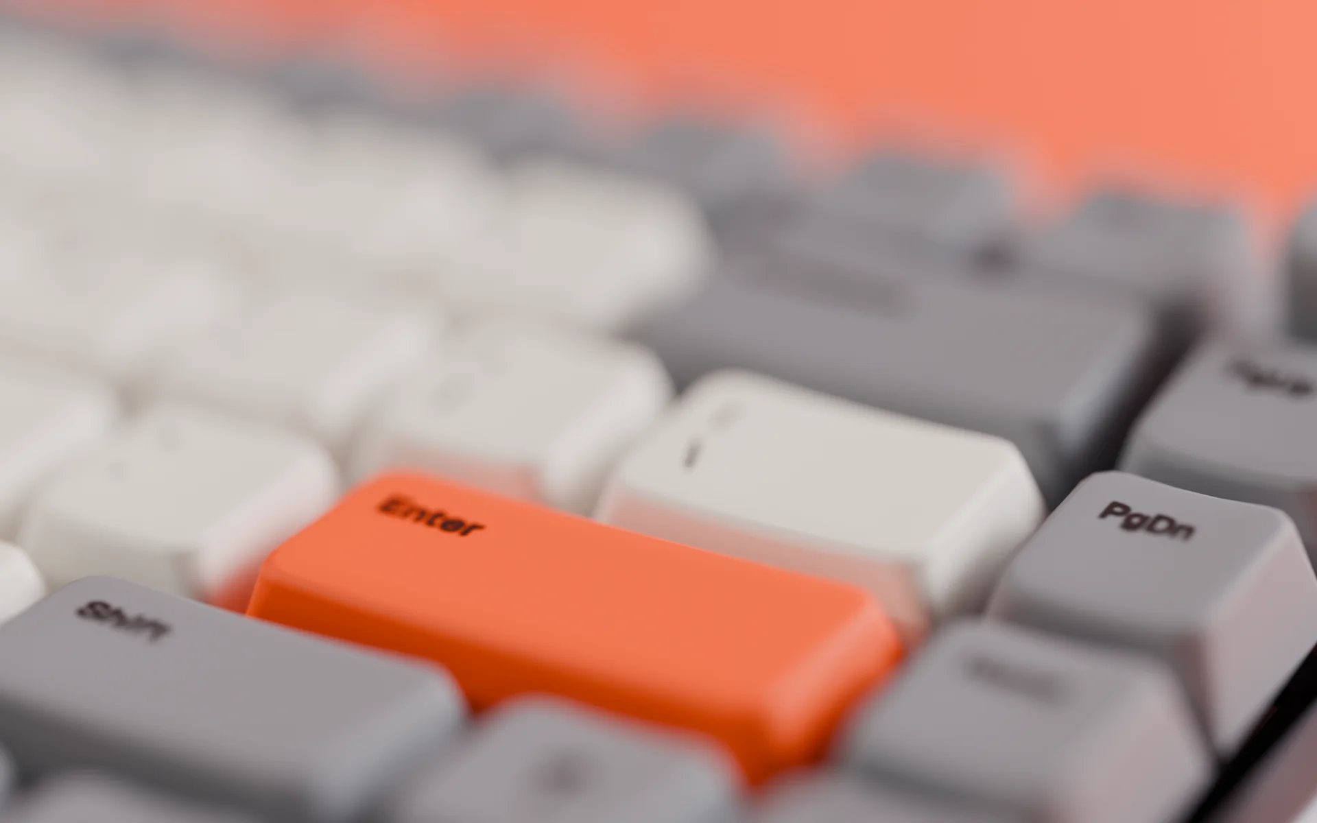 Close-up of the orange Enter key between grey Shift and PgDn keys, with the textured PBT surface in sharp focus.